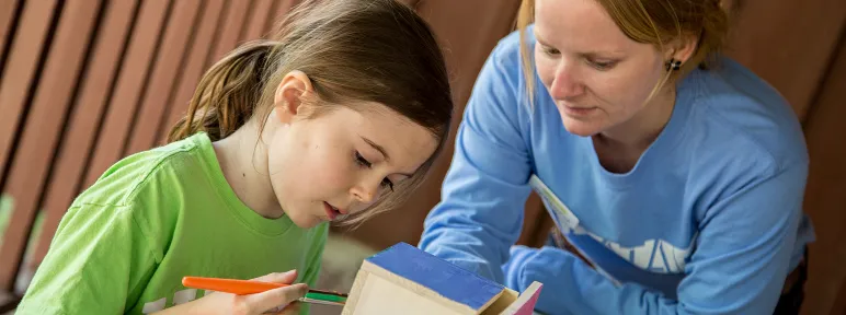 Mom and daughter painting a birdhouse