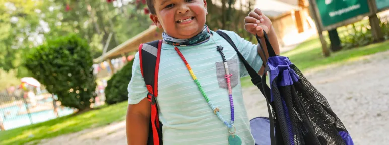 Boy with backpack and character bead necklace