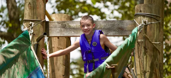 A camper getting ready to slide down the slide. 