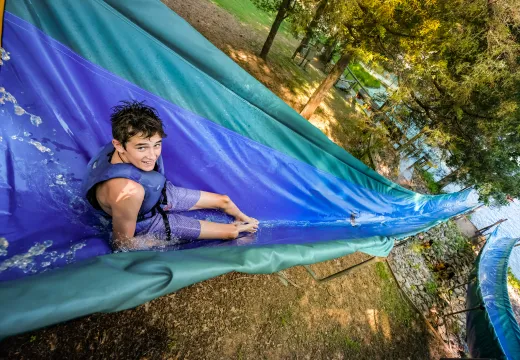 Boy on waterslide at camp Kanata